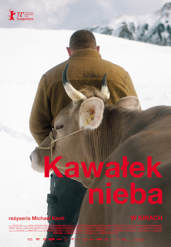 Plakat filmowy. Na tle śniegu i ośnieżonych gór mężczyzna odwrócony do widza tyłem, w zimowej brązowej kurtce, prowadzi byka. Widzimy głowę i fragment tułowia tego byka. Czerwony napis 