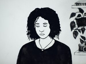 kadr z animacji. portret dziewczyny z ciemnymi kręconymi włosami, patrzącej w dół. czarno-biały