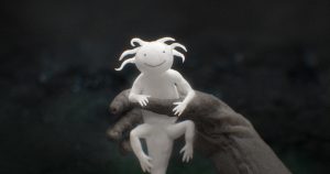 kadr z animacji. biała postać, wyglądająca trochę jak jaszczurka z wypustkami na głowie, trzymana w ciemnej dłoni.