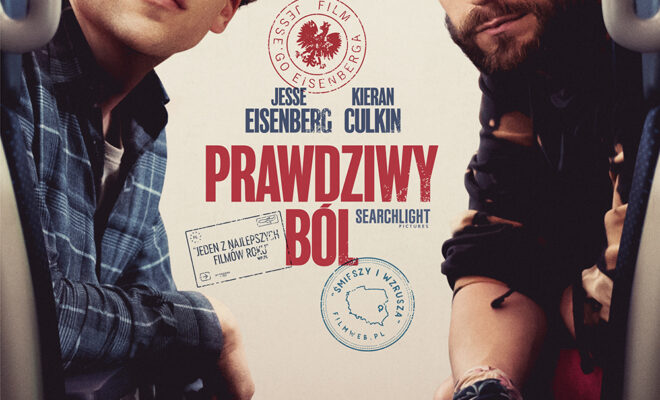 dwóch mężczyzn siedzi obok siebie, jeden z kręconymi włosami, w czapoeczce i kraciastej koszuli, w okularach. drugi z zarostem, w ciemnej koszuli. pierwszy patrzy w górę, drugi w stronę widza.