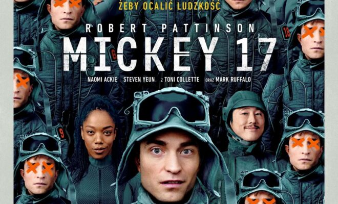 Robert Pattinson w centrum w zielonym skafandrze, otoczony przez klony swojej postaci z pomarańczowymi znakami "X" na twarzach. W tle widoczni są również inni bohaterowie, w tym postacie grane przez Naomi Ackie, Stevena Yeuna, Toni Collette i Marka Ruffalo. Tytuł "Mickey 17" jest wyeksponowany dużymi, białymi literami.