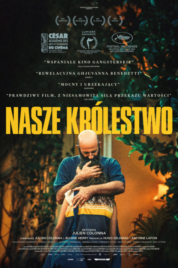 na tle roślin, mężczyzna z brodą, łysy, w niebieskiej koszulce, przytula dziewczynę z plecakiem na ramieniu.