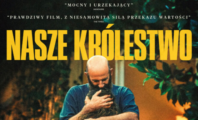 na tle roślin, mężczyzna z brodą, łysy, w niebieskiej koszulce, przytula dziewczynę z plecakiem na ramieniu.