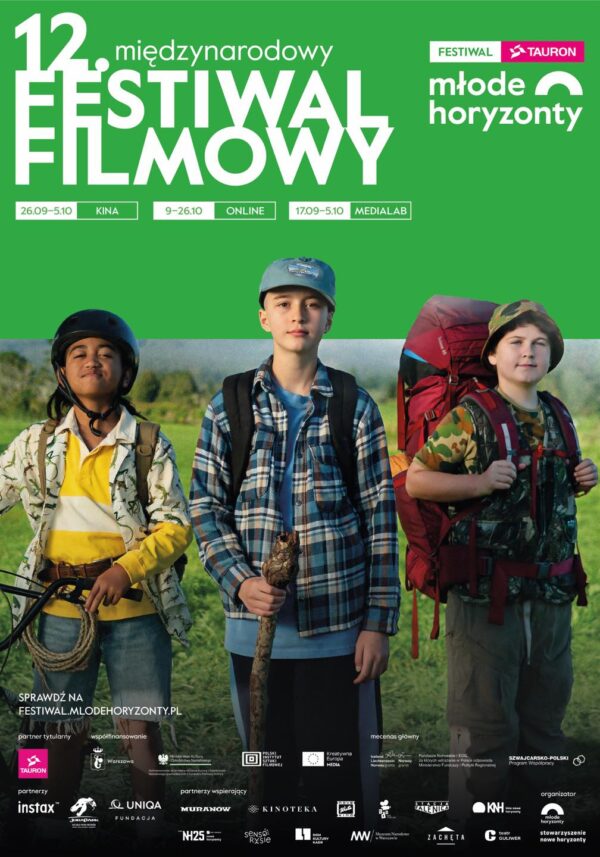 plakat. ciemnoskóra dziewczyna w kasku, kolorowej koszuli, dźinsach, trzyma rowe, obok niej chłopak w czapeczce, w kraciastej koszuli, z plecakiem i kijem w ręku, obok niego chłopiec w kolorowej koszuli, z dużym czerwonym plecakiem. W tle zieleń - plener.