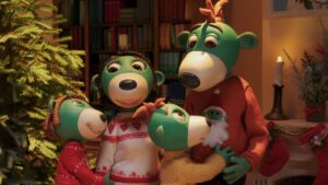 rodzina 4 zielonych misiów zgromadzona przy choince w pomieszczeniu