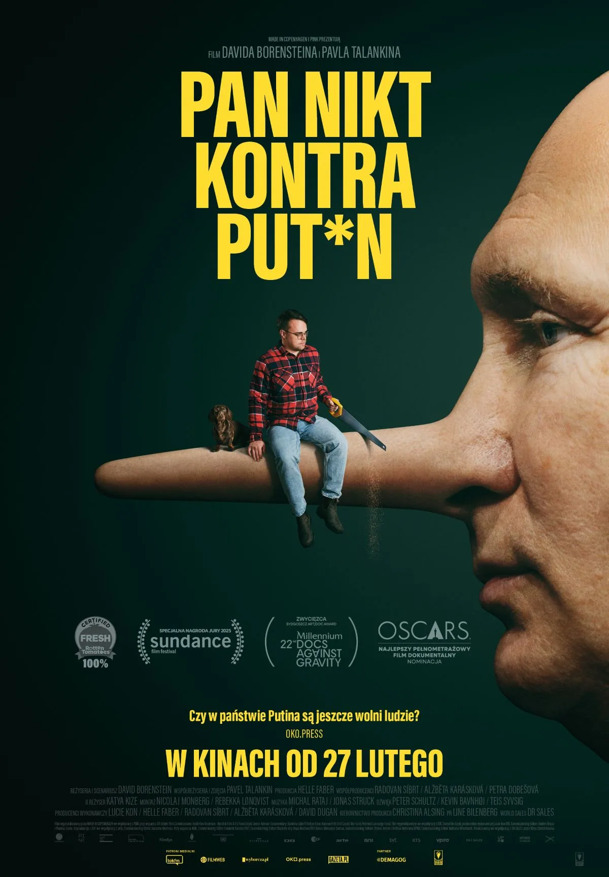 plakat - portret osoby przypominającej Putina z profilu, z nosem jak pinokio, na nosie siedzi mężczyzna w dżinsach i koszuli w kratę.