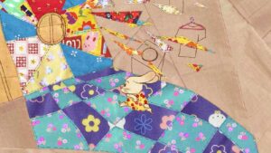 Kadr z filmu animowanego. Króliczek w zółto-czerwonej sukience biegnie po kolorowym dywanie. Nad nim unoszą się trójkątne skrawki różnych tkanin.