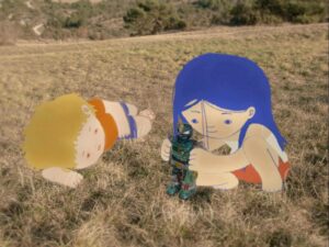 Kadr z filmu animowanego. Łąka, w tle fragment polnej drogi. Dziewczynka o niebieskich włosach bawi się robotem, chłopiec leży obok i patrzy na nią.