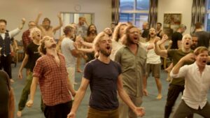 grupa ludzi, gestykulują i śpiewają