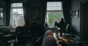 kobieta siedzi na parapecie okna, światło dzienne oświetla jej sylwetkę z boku