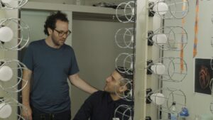 dwóch mężczyzn - odbicie w lustrze w garderobie. jeden trzyma rękę na ramieniu drugiego